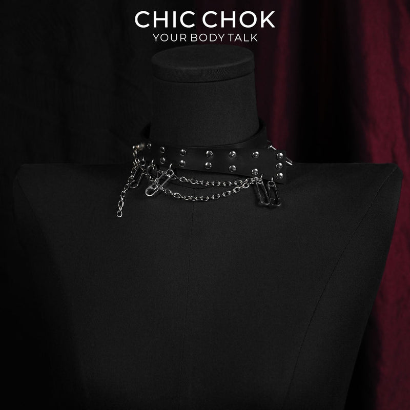 Black strap choker with rivets, safety pins, and hanging chains on a necklace display