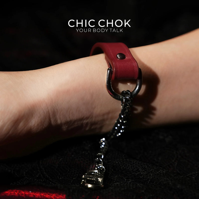 Breathless bracelet catalog detail showing a red band, large ring and hanging chain hardware on one wrist