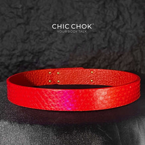 A vibrant red textured leather bracelet featuring a gold-tone stainless steel lock closure, designed by CHICCHOK for bold and luxurious style. Ideal for versatile fashion statements and perfect as a gift.