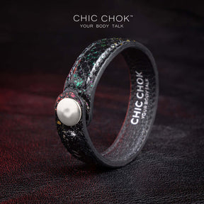 Nebula Doll Bracelet Luxurious black leather bracelet with textured scales, adorned with shimmering multicolor glitter accents, inspired by the brilliance of a starry night sky, showcasing elegance and individuality.